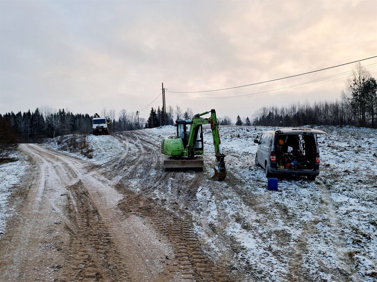 Maakaabli kaevetööd talvel — Sennebogen ekskavaator ja töösõiduk maanteel